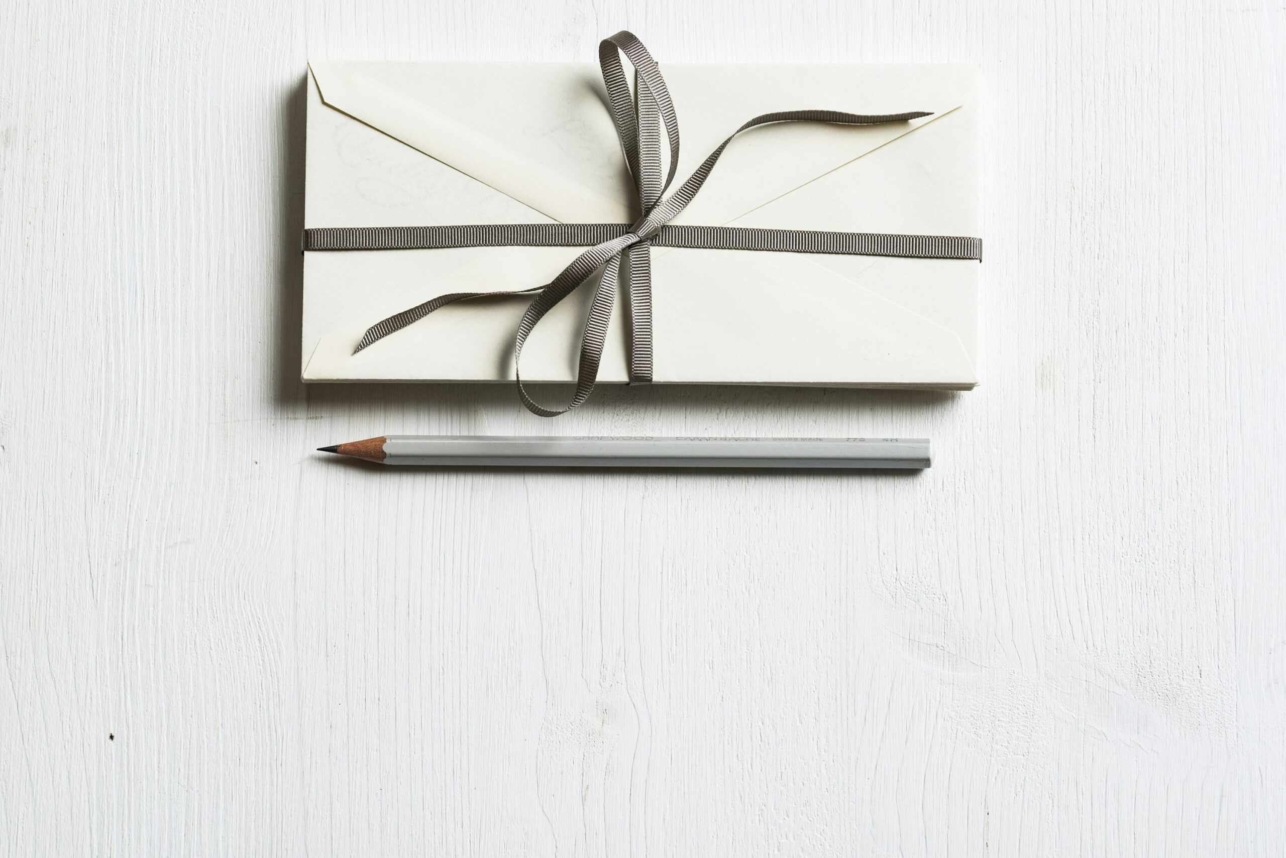 photo 1494426383302 7b9d36a1a028 - Magvilla white envelop and gray pencil on white panel